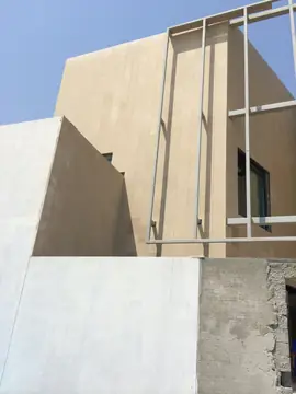 Volúmenes aplacados y estructura metálica. Volúmenes de fachada revestidos en tono arena con la estructura metálica exterior montada y el zócalo pendiente.