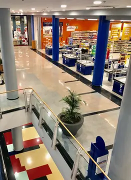 Pavimento de la galería frente a las cajas. Vista desde la planta alta del pavimento pulido en piezas claras y grises con bandas negras junto a la zona de cajas.