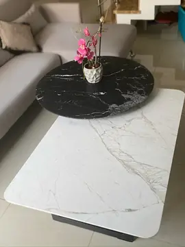 Mesas bajas con sobre blanco y redondo negro. Mesa de centro con sobre blanco de veta gris y sobre redondo negro de vetas blancas superpuesto.