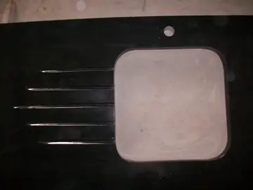 Encimera negra con escurridor ranurado. Encimera negra pulida con ranuras de escurridor, hueco de fregadero y taladro de grifo, sobre el suelo del taller.