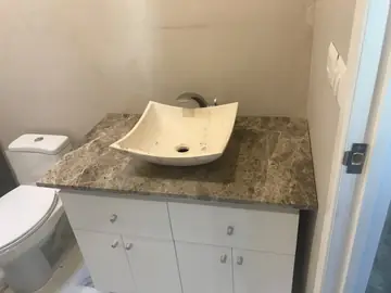 Encimera de baño marrón con lavabo crema. Mueble de baño con encimera marrón veteada y lavabo sobre encimera en tono crema.