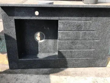 Fregadero con escurridor en pieza gris. Fregadero con escurridor ranurado en pieza gris moteada, antes de su colocación.