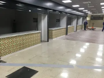 Pasillo con puestos y mostradores. Hilera de puestos con mostradores de encimera blanca y frente de baldosa decorada, con los remates en marcha.