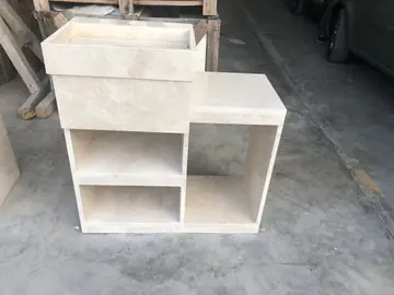 Mueble de lavabo en tono crema en taller. Mueble de lavabo en tono crema con seno rectangular y estantes abiertos, en el taller.