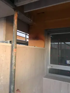 Encuentro del aplacado con una ventana. Piezas en tono crema rematando el hueco de una ventana sobre el aislamiento proyectado, con vierteaguas a juego.