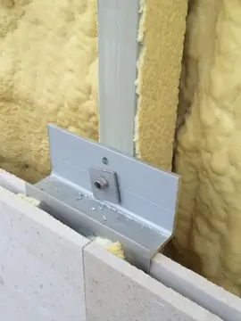 Grapa de sujeción sobre el aislamiento. Grapa metálica atornillada al perfil que sujeta el canto superior de las piezas, sobre aislamiento proyectado.