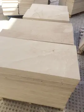 Piezas apiladas en palés. Palés con piezas en tono crema y veta suave apiladas a pie de obra antes de su colocación.