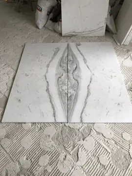 Piezas casadas con la veta en espejo. Piezas blancas con la veta gris enfrentada en espejo, sobre el suelo con el adhesivo peinado.