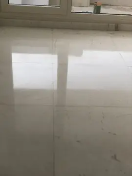 Brillo del pavimento blanco pulido. Reflejo de la luz del ventanal sobre el suelo de piezas blancas pulidas con vetas grises finas.