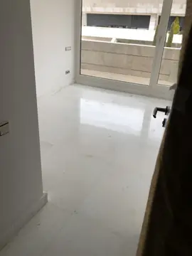Estancia con suelo blanco pulido. Estancia con pavimento blanco de veta gris en gran formato y rodapié a juego, abierta a la terraza.