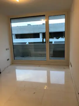 Estancia con pavimento pulido y terraza. Suelo blanco con veta gris en piezas grandes que refleja la puerta de salida a la terraza.