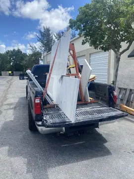 Transporte de encimeras en caballete. Piezas de encimera blanca con veta gris sujetas a un caballete sobre la caja de una camioneta.