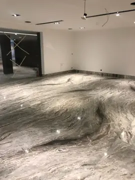 Sala con pavimento pulido veteado. Sala diáfana con pavimento pulido en gris y blanco de vetas onduladas y rodapié a juego.