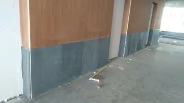 Zócalo oscuro en piezas grandes. Zócalo gris oscuro en piezas grandes bajo paneles en tono madera, con el pavimento a juego ya colocado.