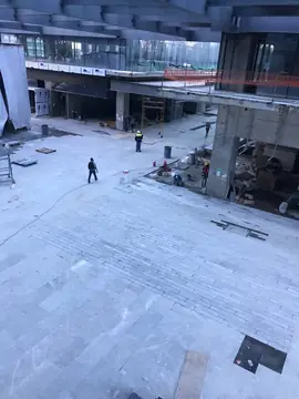 Pavimento gris claro de la plaza en remates. Plaza con pavimento gris claro en piezas alargadas y piezas grandes con veta blanca, a falta de completar algunos huecos.