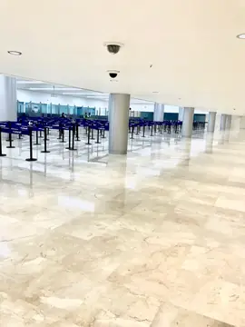 Sala con columnas y pavimento pulido. Sala amplia con pavimento pulido en tono crema con vetas, columnas y cintas separadoras al fondo.