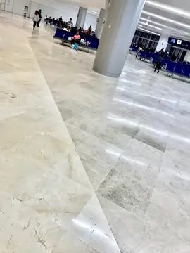 Encuentro de pavimento crema y gris. Pavimento pulido con encuentro en diagonal entre piezas en tono crema con vetas y piezas en tono gris claro moteado.