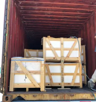 Cajas de madera estibadas en contenedor. Contenedor abierto con cajas de madera apiladas en dos alturas y protegidas con film.