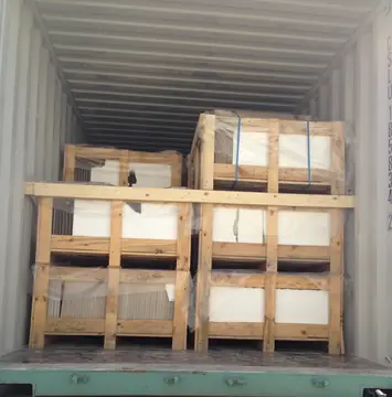 Cajas de madera apiladas en un contenedor. Cajas de madera con poliestireno y film apiladas en la boca de un contenedor abierto.