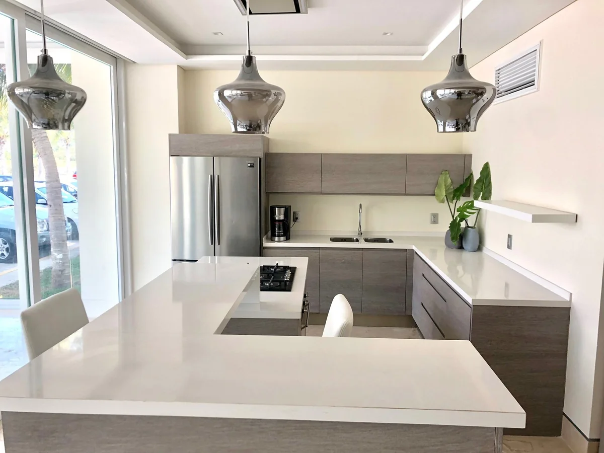 X Towers: cocina con isla bajo lámparas colgantes